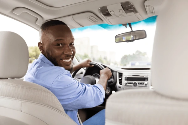 Professional Qwikab driver smiling from the driver's seat